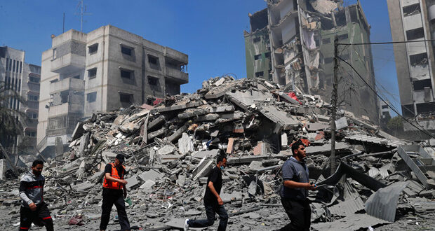 People inspect the the rubble of the Yazegi residential building that was destroyed by an Israeli airstrike, in Gaza City, Sunday, May 16, 2021. The 57-member Organization of Islamic Cooperation held an emergency virtual meeting Sunday over the situation in Gaza calling for an end to Israel’s military attacks on the Gaza Strip. (AP Photo/Adel Hana)