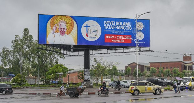 A billboard shows the image of Pope Francis in Kinshasa on January 22, 2023 ahead of his visit on January 31, 2023. - In DR Congo's bustling capital Kinshasa, the faithful are flocking to impromptu market stalls in churchyards to buy t-shirts and wax tissues adorned with the image of Pope Francis, ahead of the pontiff's visit. (Photo by Arsene Mpiana / AFP)